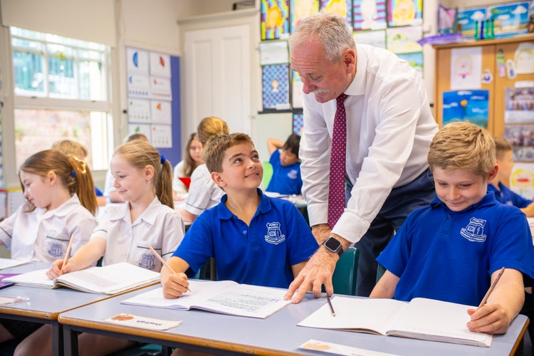Principal helping students in class with work