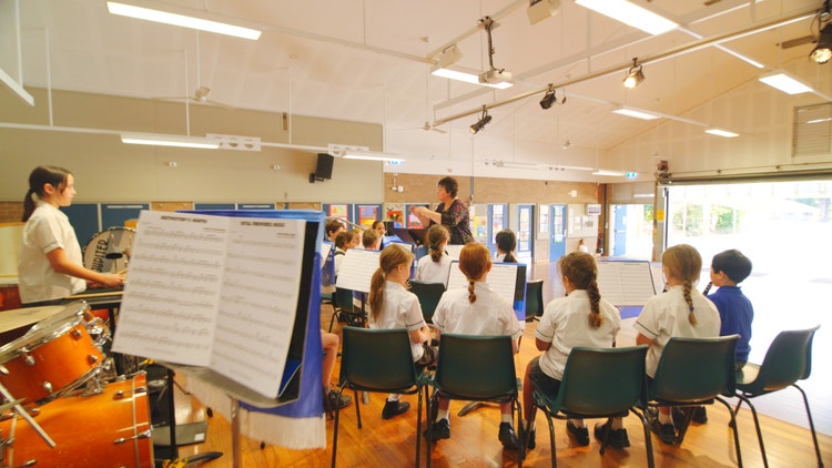 Music studnts performing in hall with music teacher